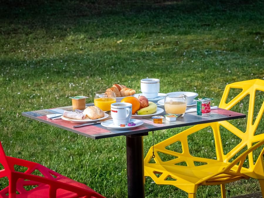 Breakfast served on an outdoor dining table at Originals Hotels