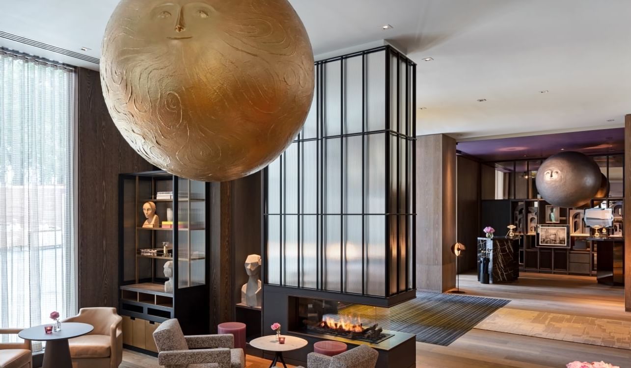Elegant interior of lobby at The Londoner with a large moonhead sculpture, sitting area, and fire pit