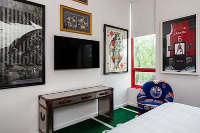 Queen bed, TV, stylish chair & captivating paintings in Queen Premiere at Retro Suites Hotel