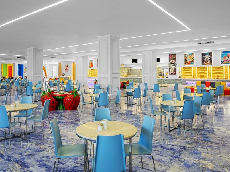 Blue chairs and tables arranged in a colorfully decorated bakery station at Neverland City Hurghada in Hurghada.