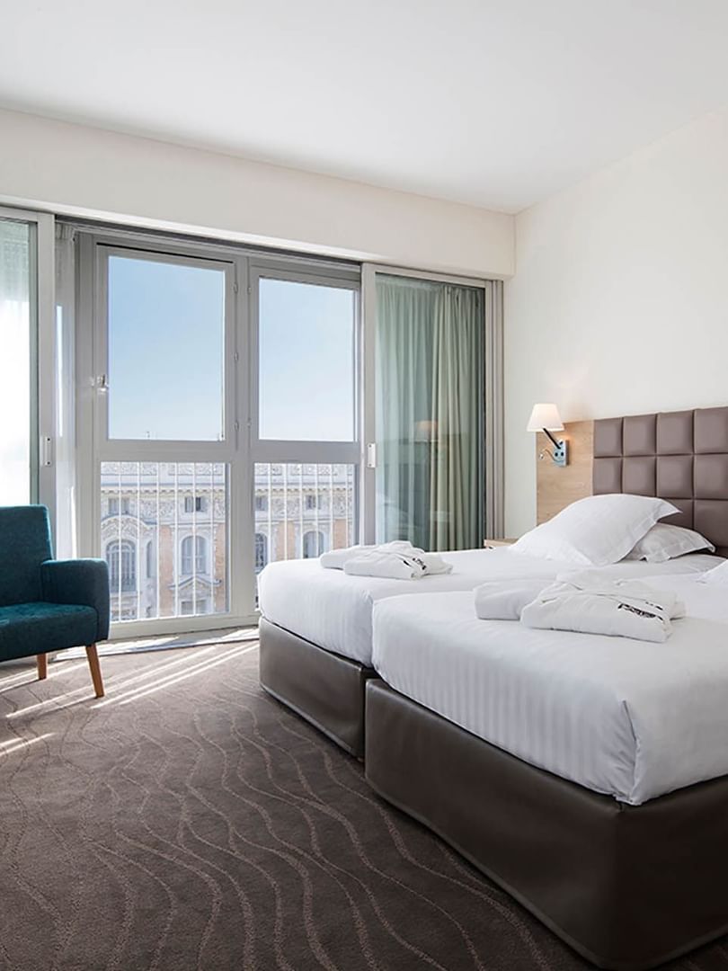Deux lits simples dans la suite avec vue sur la ville au Splendid Hotel & Spa Nice