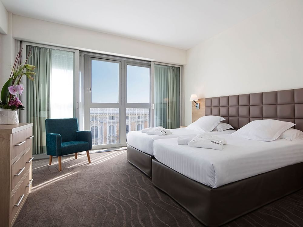 Deux lits simples dans la suite avec vue sur la ville au Splendid Hotel & Spa Nice