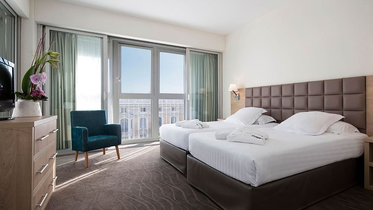 Deux lits simples dans la suite avec vue sur la ville au Splendid Hotel & Spa Nice