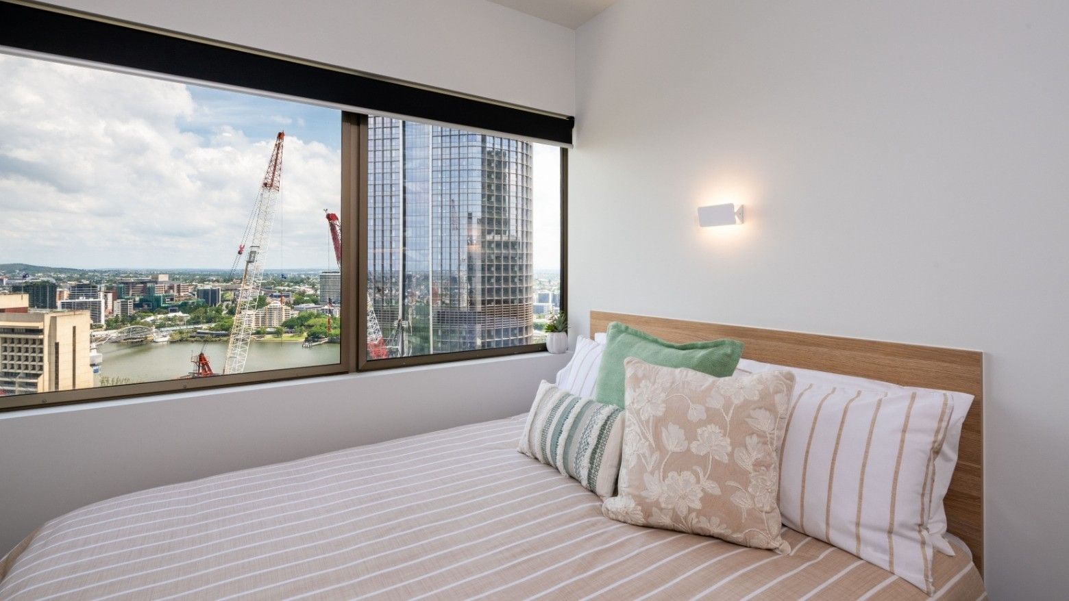 Cozy bed with floral pillows in a modern room at UniLodge Brisbane City.