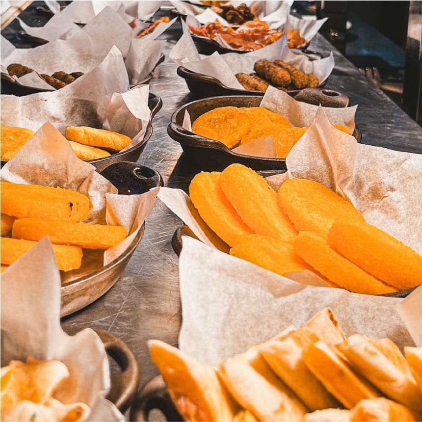 Aperitivos dorados y fritos en bandejas forradas con papel sobre el bufé de Bazaar en Megapolis Hotel Panama
