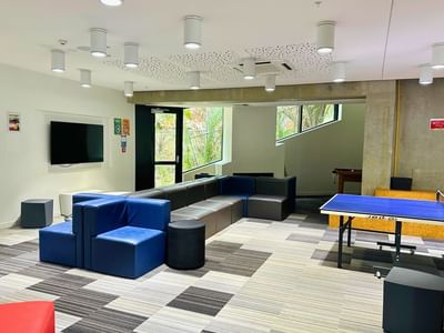 Comfortable lounge area with a ping pong table and large TV at UniLodge Auckland City.
