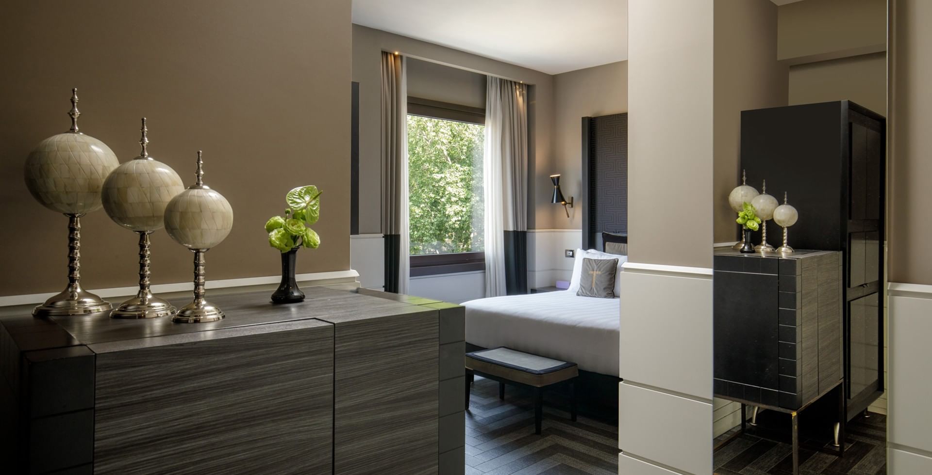 King Bed Premier room at Tribune Hotel Rome with elegant modern décor, stylish furnishings, spacious king bed, and large windows with natural light and greenery views.