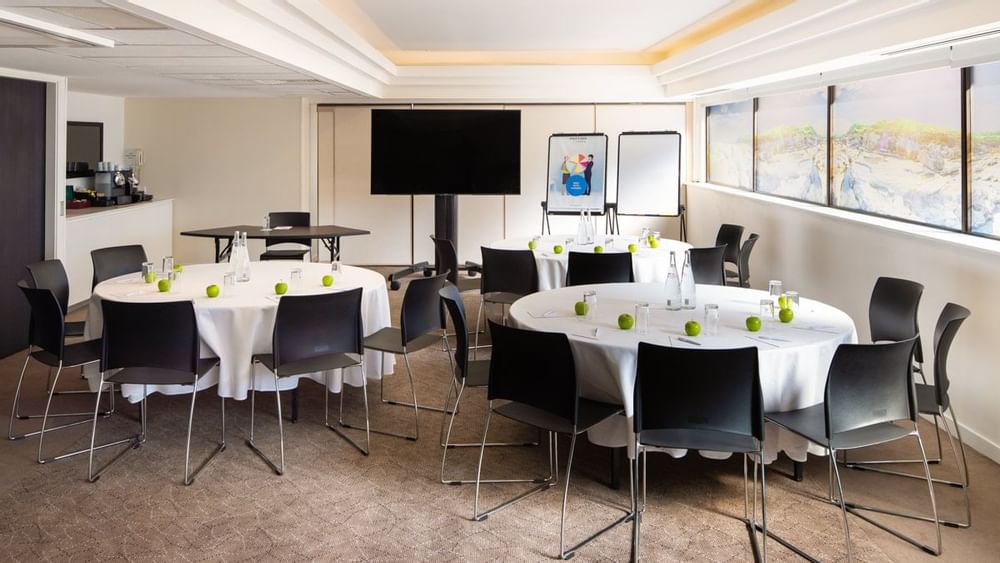 Banksia featuring setup banquets facing a large screen by the windows at Novotel Sydney International Airport