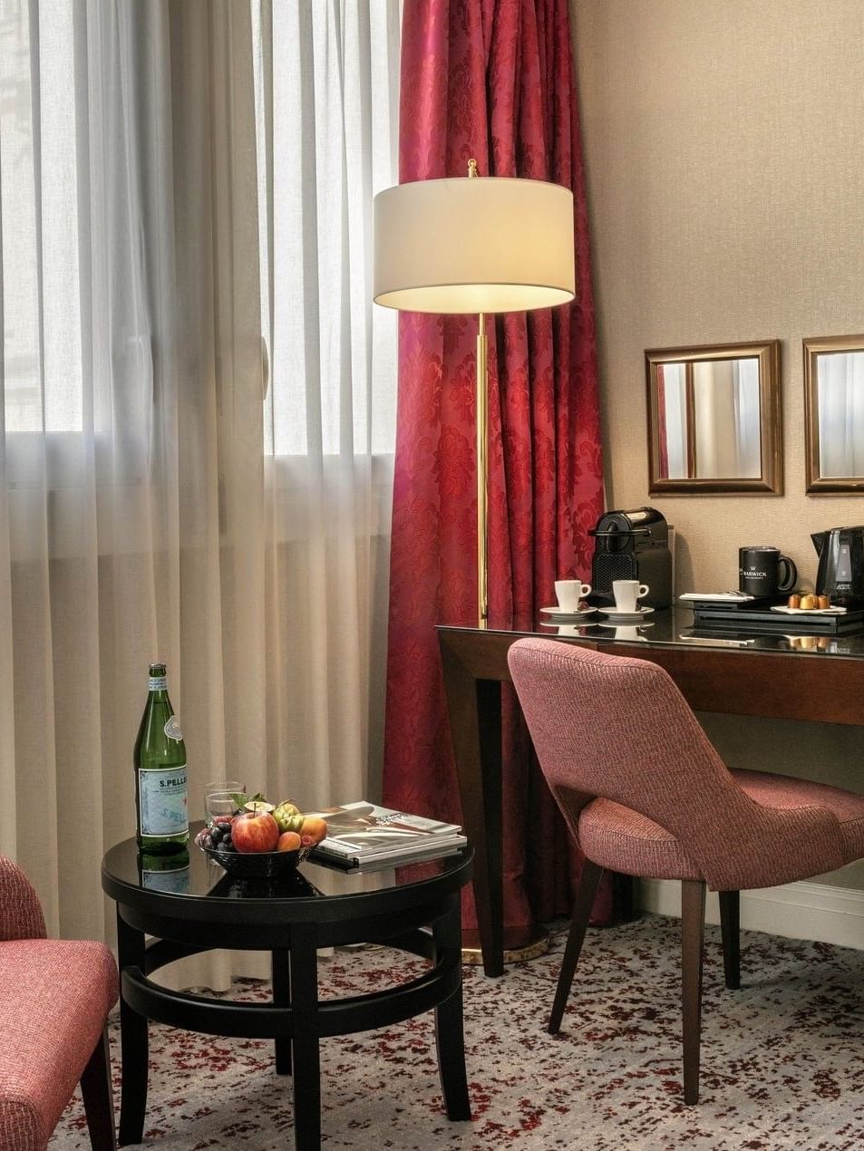 Deluxe Room features Wooden desk with a pink chair by a floor lamp under gold mirrors at Warwick Paris Champs Elysées