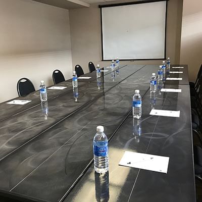 Meeting table arranged with water bottle, papers and pens at Fort McMurray Hotel