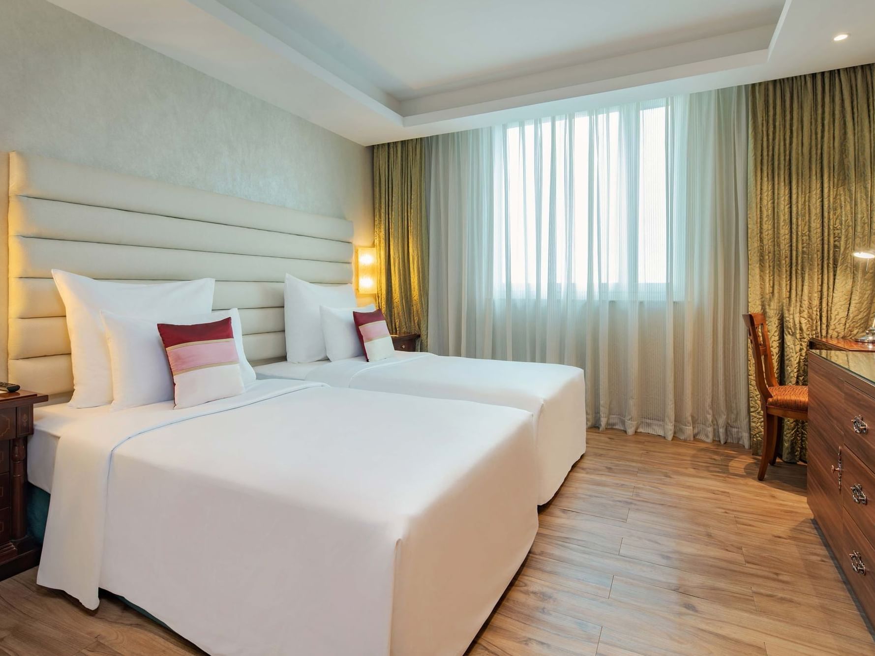 spacious hotel room with combined twin beds and television in front