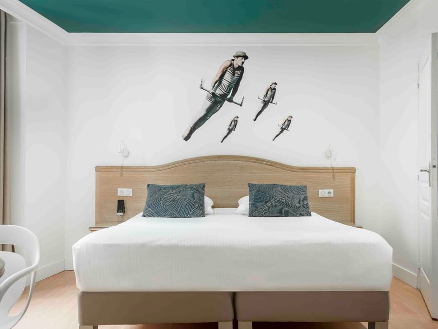 Double bed with a wall art in room at The Originals Hotels