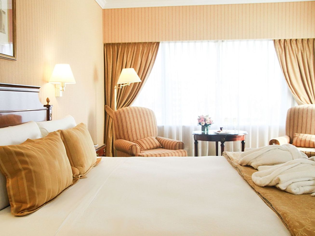 Corner suite with a cozy bed in Hotel Emperador Buenos