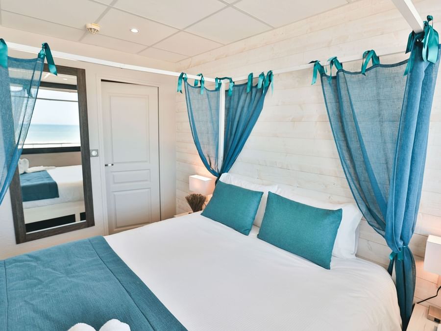 Bed with curtains in Hotel Neptune at The Originals Hotels