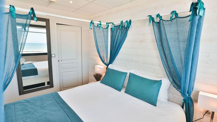 Bed with curtains in Hotel Neptune at The Originals Hotels