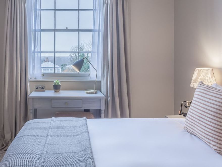 Bed beside a working desk in Georgian Single at Richmond Hill