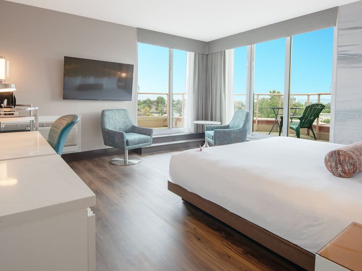 Hotel guestroom with a king size bed and two chairs