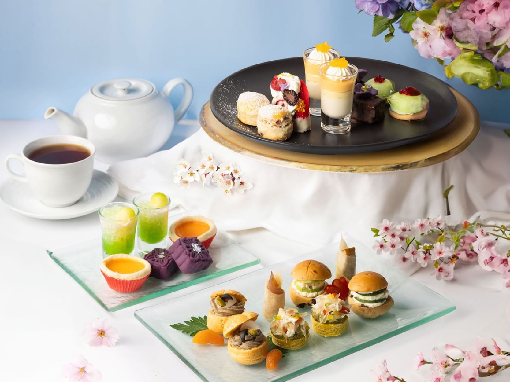 A table set with an assortment of desserts and tea cups