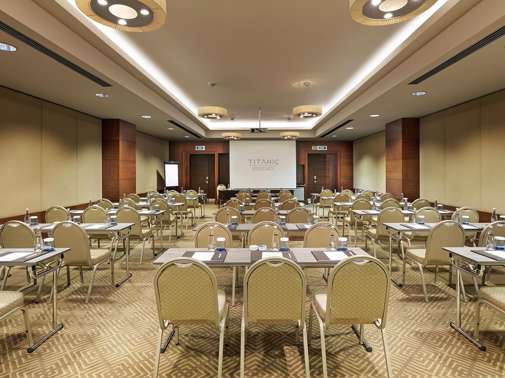  Titanic Business Kartal’daki Borneo salonunda, sınıf düzeninde masa ve sandalyelerle hazırlanmış toplantı odası.