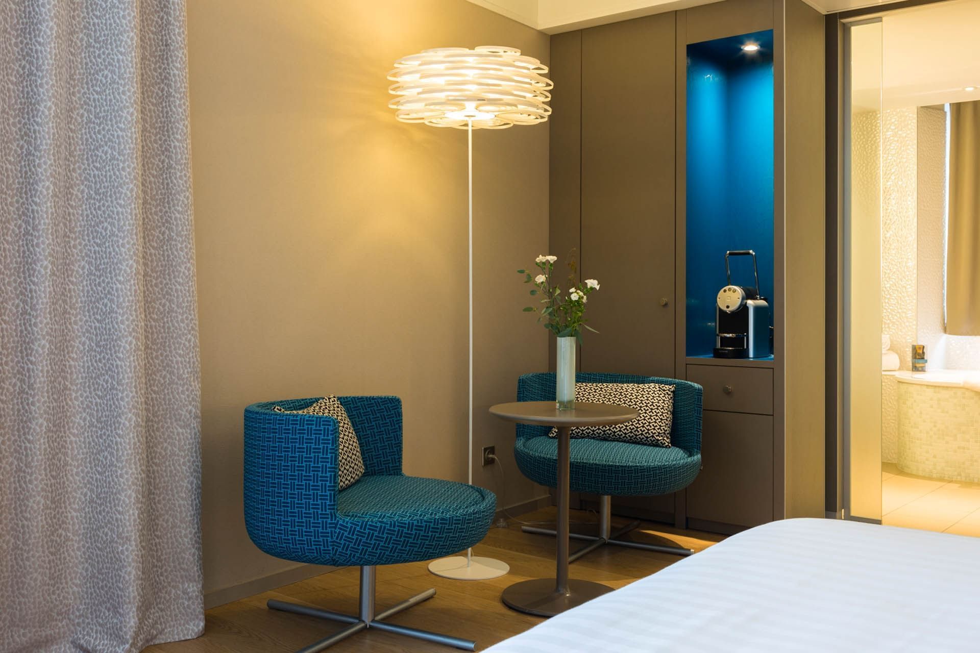 Chaises longues près du lit dans une chambre à Oceania Hôtel de France Nantes