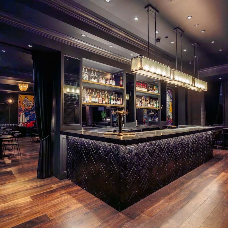 A bar with a counter and shelves of bottles