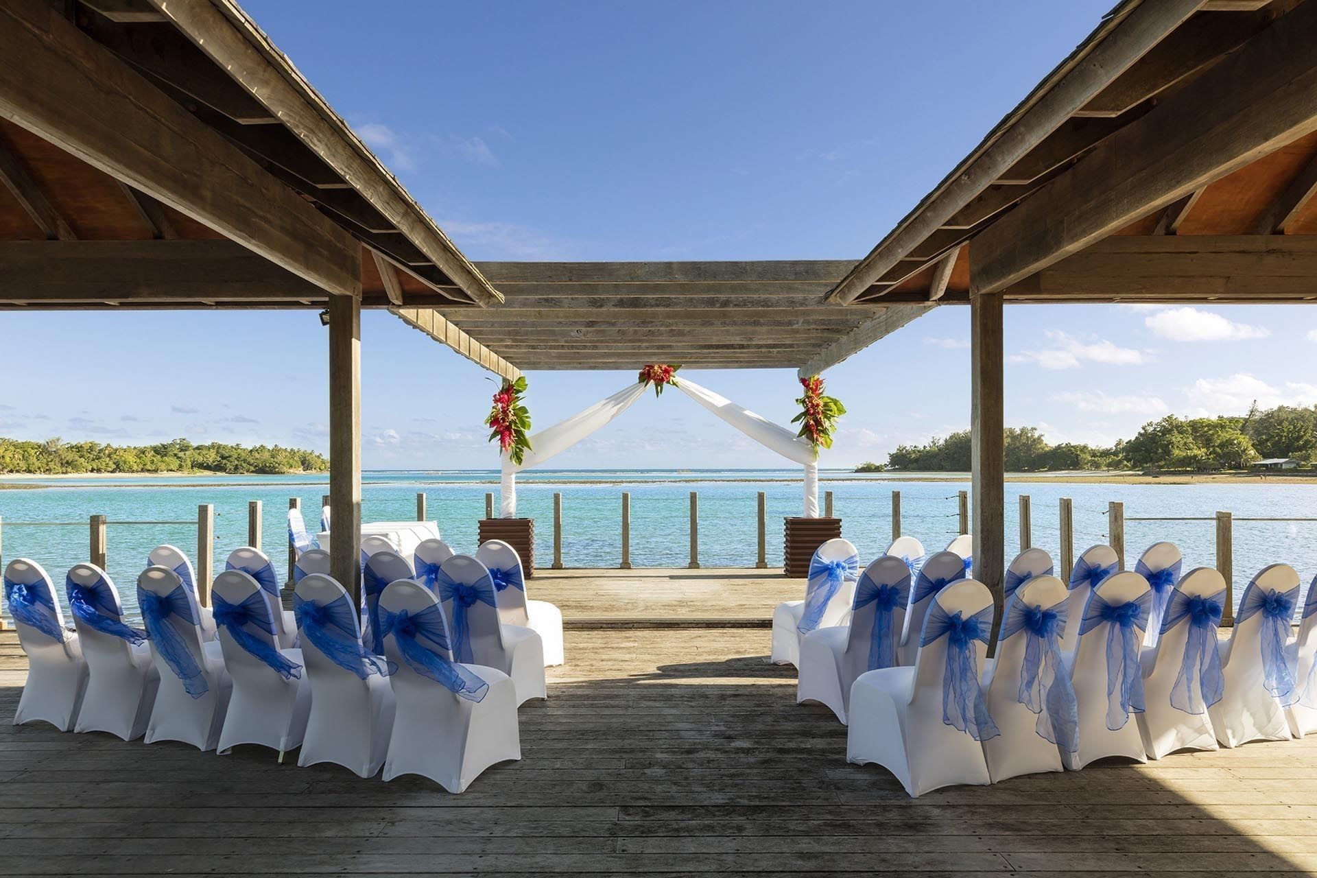 Outdoor wedding ceremony venue with blue-ribboned chairs facing the tropical ocean at warwick le lagon-vanuatu