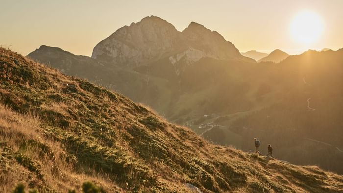 A couple on a mountain hike at a sunset near Falkensteiner Hotels & Residences