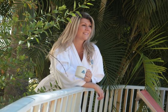 Woman drinking coffee on the balcony at Safety Harbor Resort