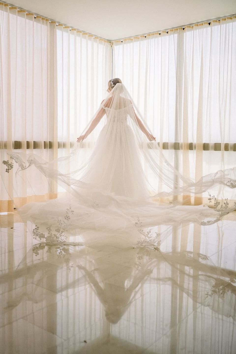 A Bride gazing by the window at Isla Verde Weddings