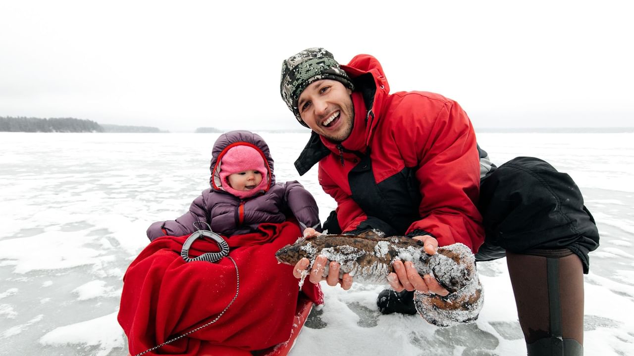 Father and child ice fishing on a lake