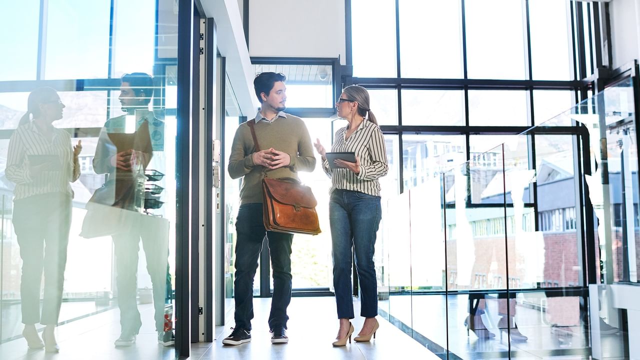Two people walking through a modern building interior