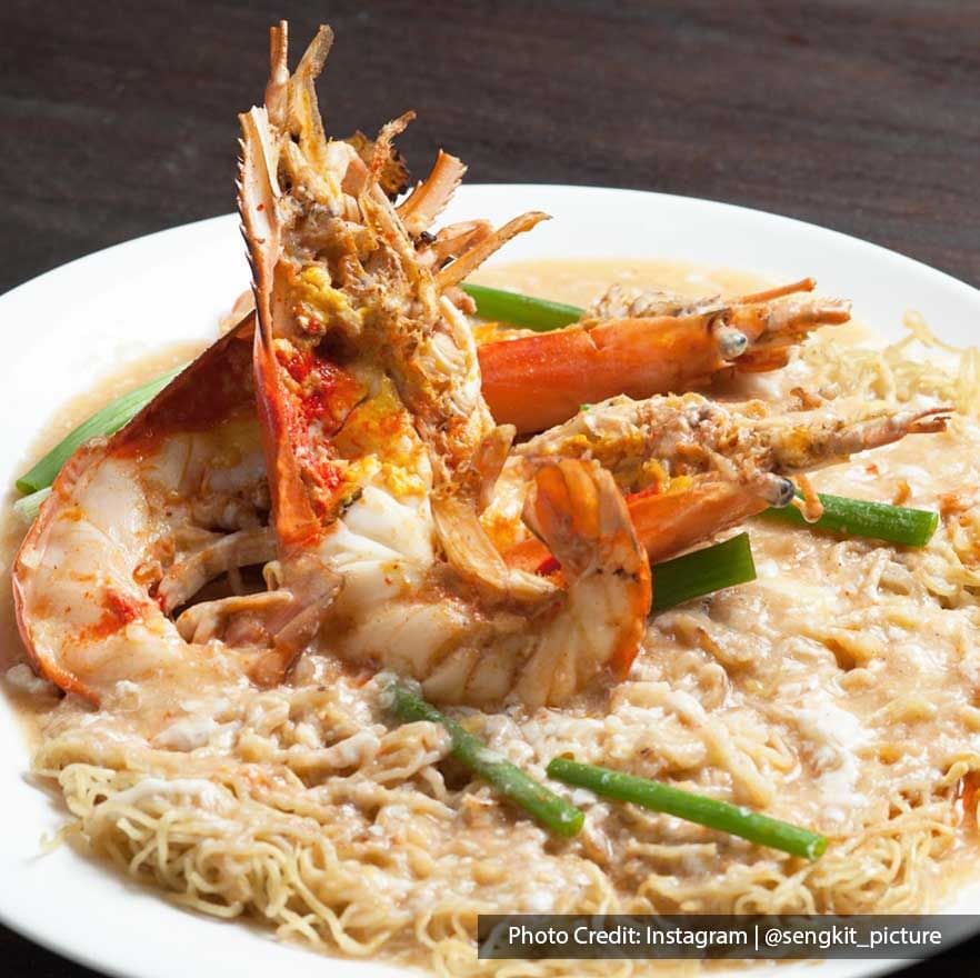 a bowl of noodle soup with big prawns