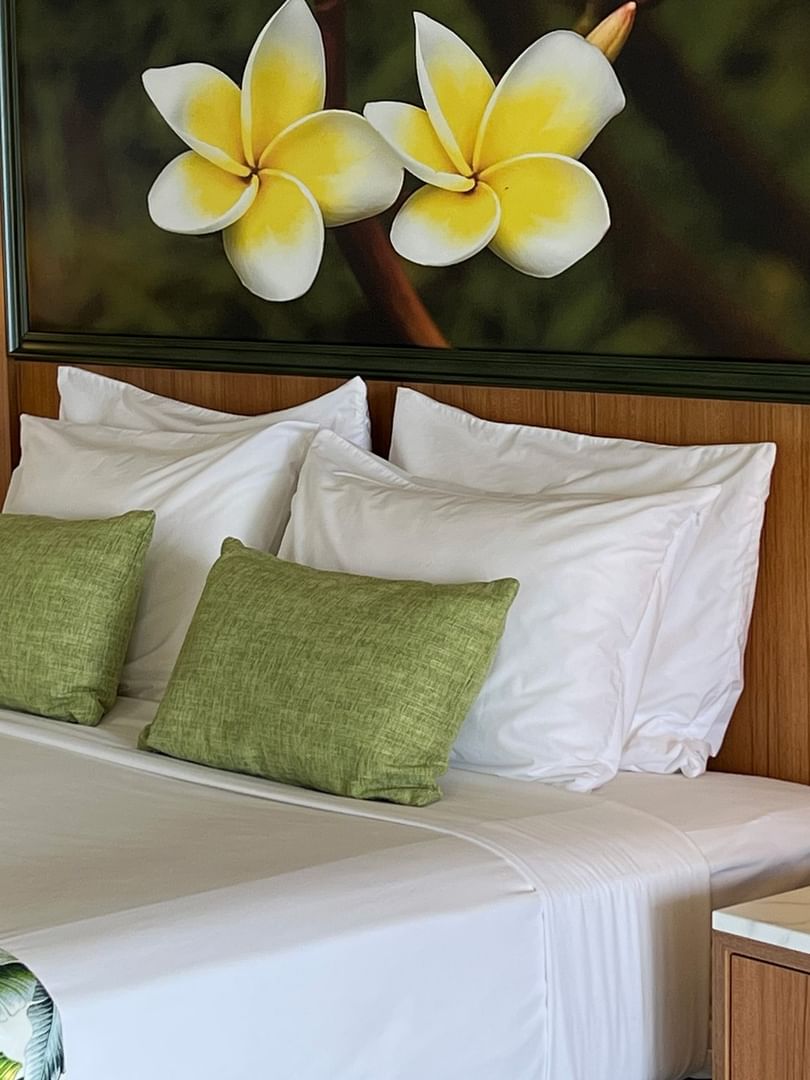 Bed with tropical decor and large floral artwork at Warwick Le Lagon - Vanuatu, Efate.