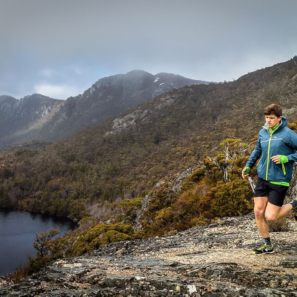 Man jogging by a cliff near Cradle Mountain Hotel  