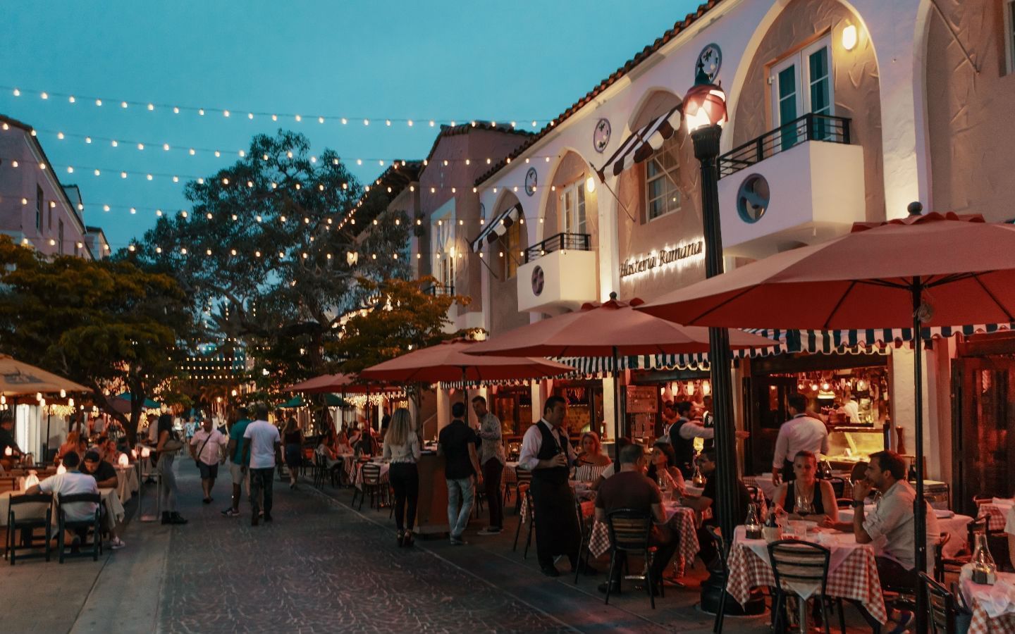 a restaurant on a street corner with people sitting at tables outside