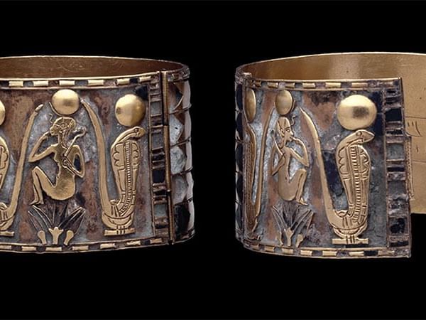 A pair of ornate ancient Egyptian gold and silver cuffs, decorated with figures of gods and serpents at The Sebel Brisbane