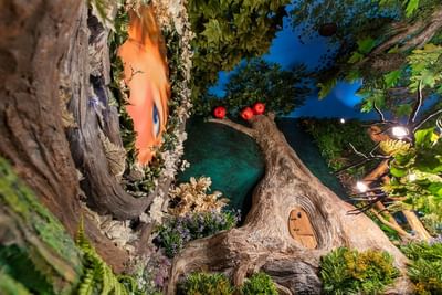 Whimsical interior of The Faerie Forest with a textured tree, and vibrant leaves at The Roxbury