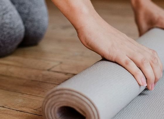 Close-up of a woman rolling a yoga mat at High Peaks Resort