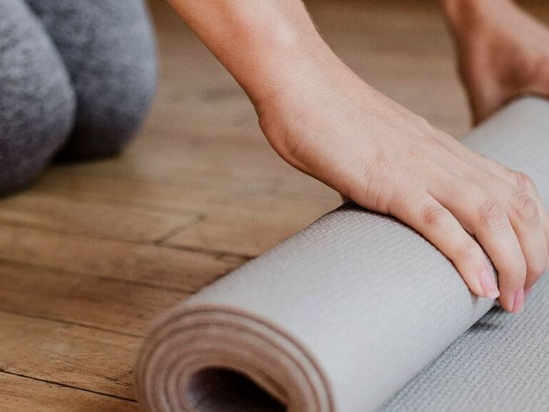 A girl rolling a yoga mat at the gym in High Peaks Resort