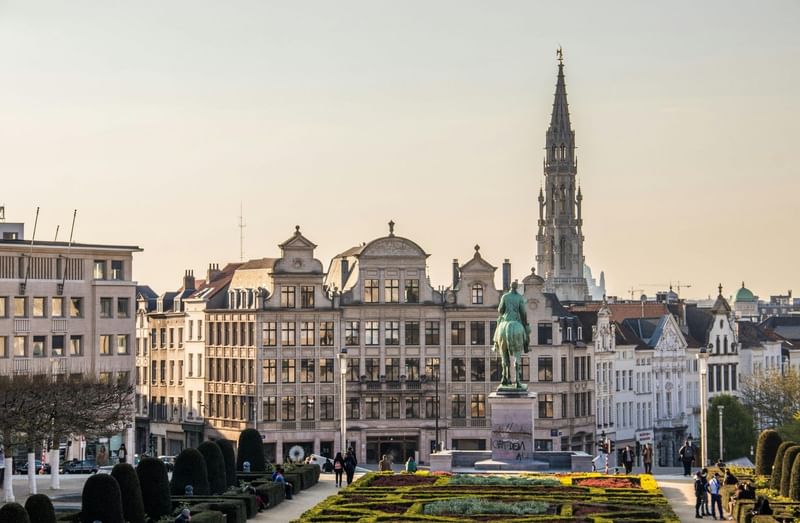 Panoramisch uitzicht op historische Brusselse gebouwen met gotische torenspits en standbeeld bij Warwick Brussels Bruxelles