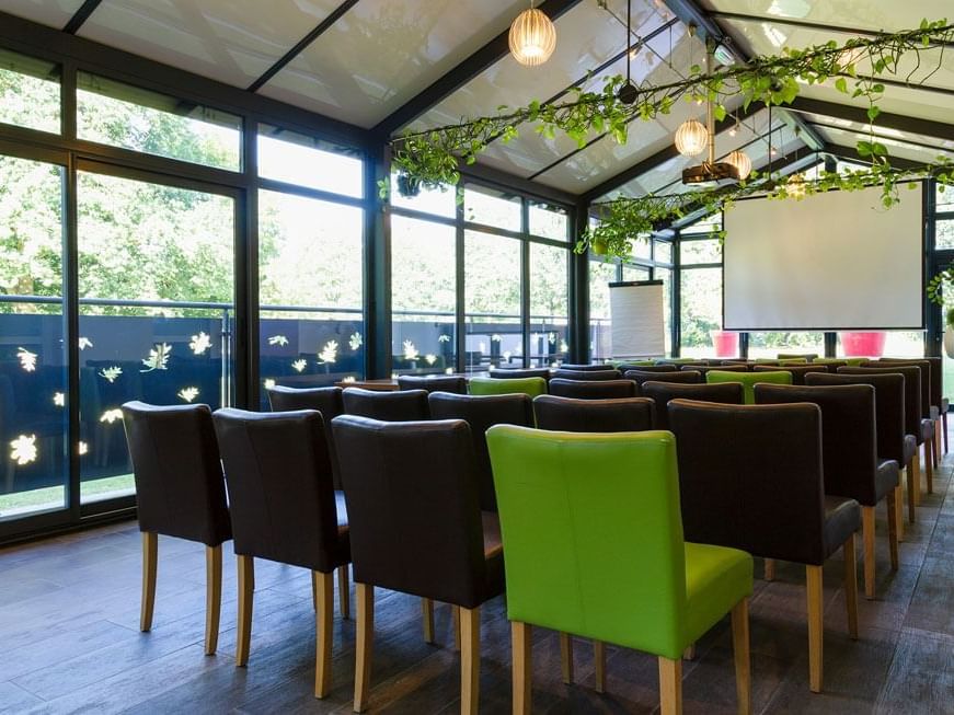 Chairs arranged facing a projector screen in The Veranda Room at Originals Hotels