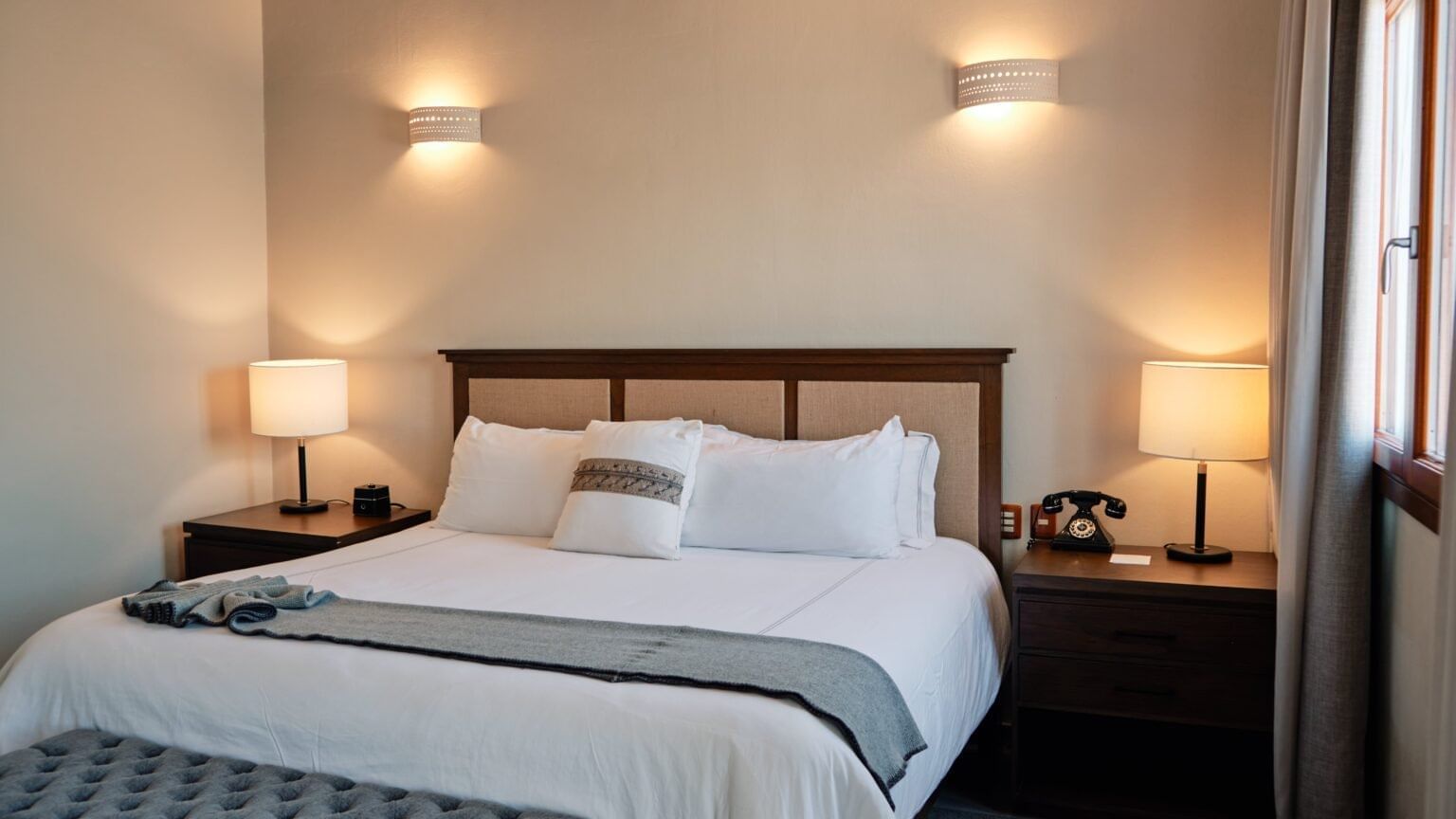 Bed and a vintage-style telephone on the nightstand in a room at Curamoria Collection