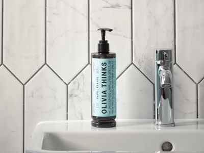 Close-up of organic Olivia Thinks hand wash beside a faucet in a modern bathroom at The Met Hotel Leeds, England