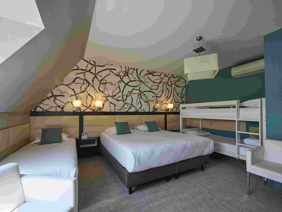 Chambre avec trois lits et décoration moderne à Hôtel La Marébaudière.