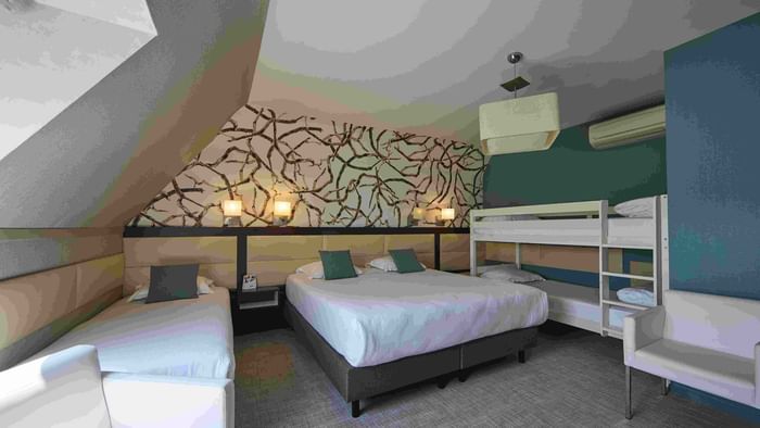 Chambre avec trois lits et décoration moderne à Hôtel La Marébaudière.