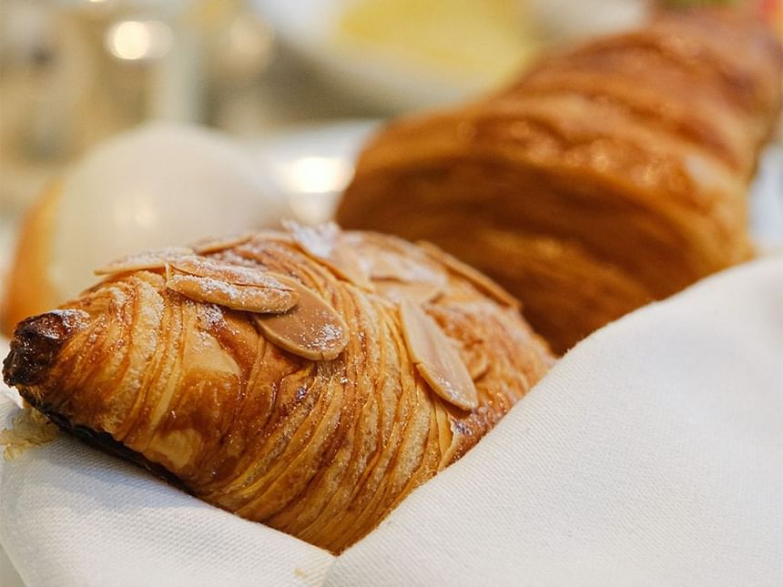 Close-up of two golden, flaky almond croissants served in Park Lounge at Park Hyatt Saigon