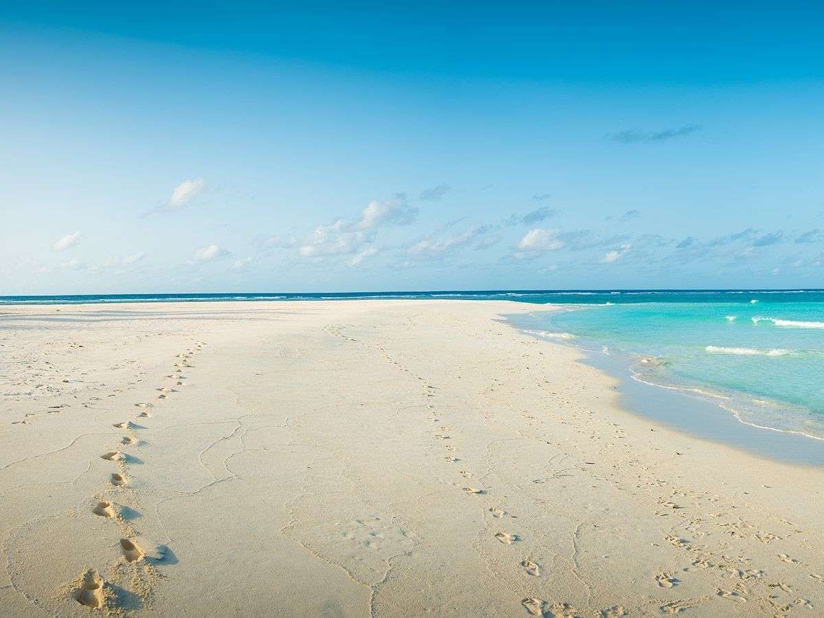 Footprints on the sandy beach near The Signature Collection