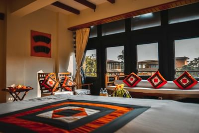 Junior Suite featuring an elegant bed with colorful geometric decor with vibrant cushions at Dwarika's Hotel Kathmandu