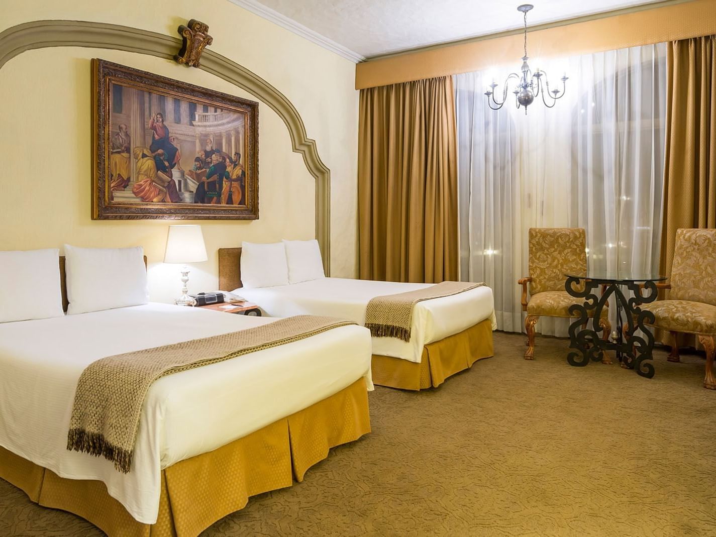 2 Double Master Suite with two beds, classic art, and gold curtains at Quinta Real Aguascalientes