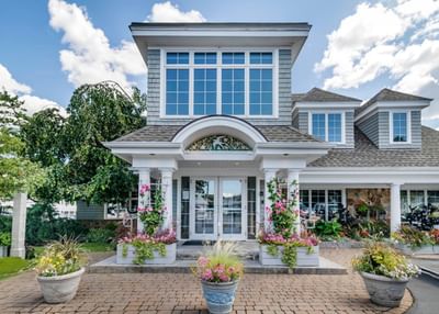 Front entrance to a building with colorful flowers and lush plants at Anchorage by the Sea